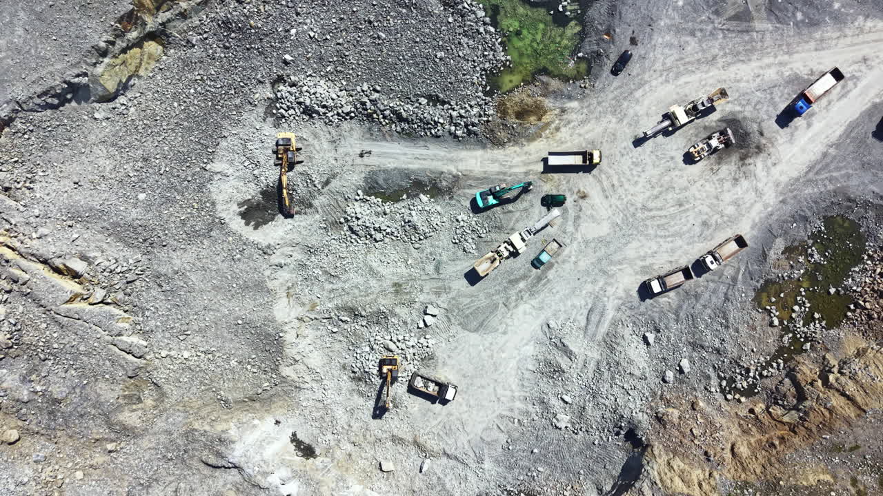 Granite quarry operations take place in a large area with various heavy machines and vehicles moving around to extract granite stones
