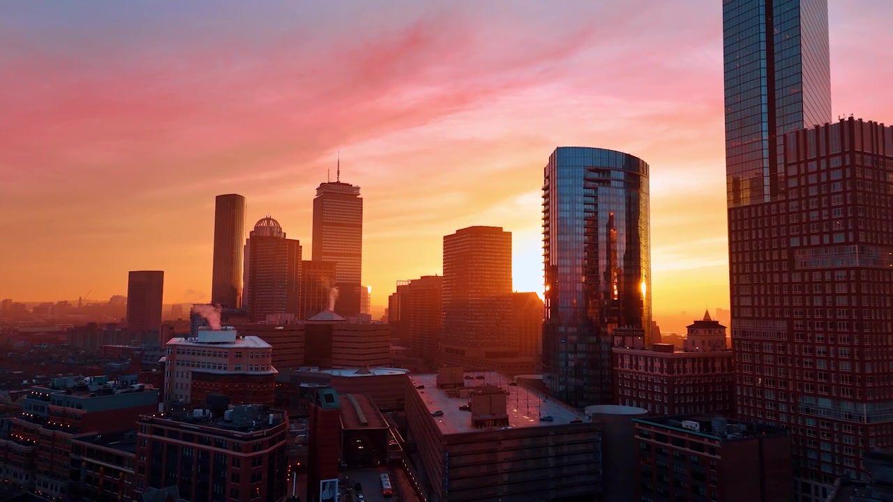 Luce rosa che colora lo scenario della bellissima Boston, Massachusetts, USA. Il fumo sale dai camini dei grattacieli. Vista aerea della città al tramonto