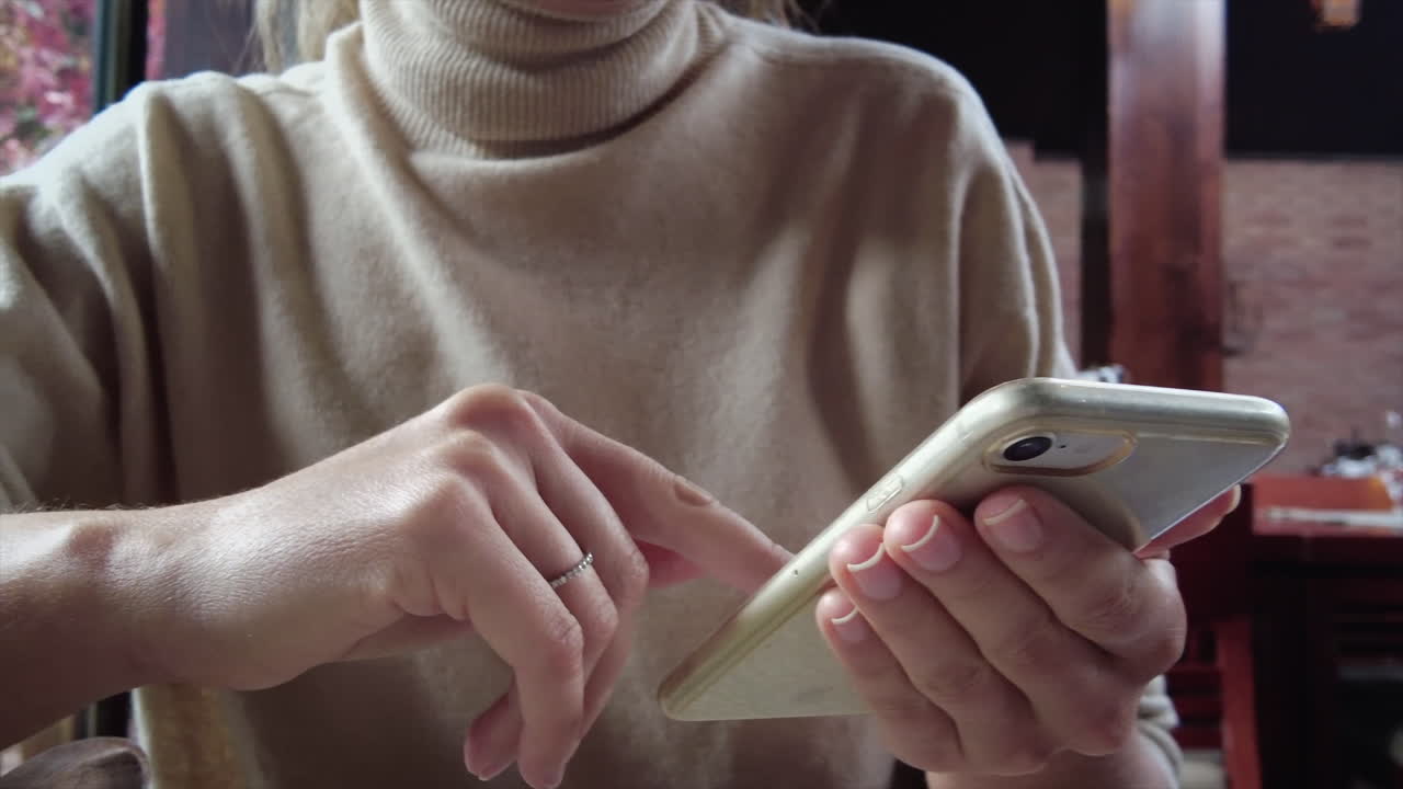 Donna che lavora al cellulare in un ristorante
