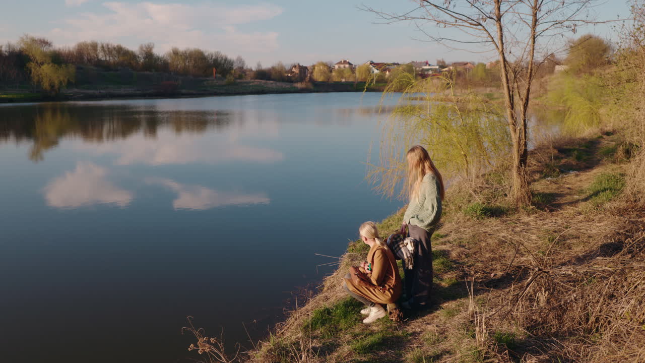 Two Women Relaxing by a River