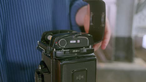 fotógrafo de película poniendo el rollo de película atrás de la cámara analógica