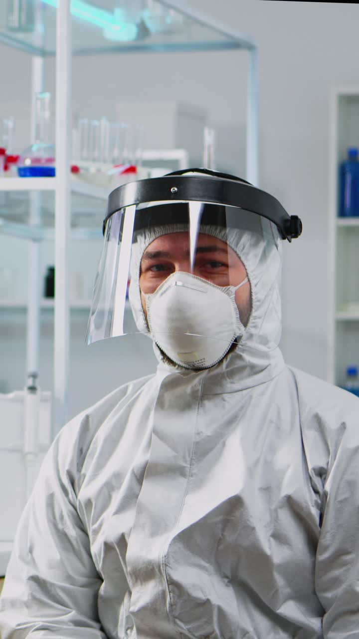 Vertical video: Portrait of tired chemist man doctor in coverall
