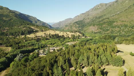 dolly bajando sobre un bosque de pinos con el valle del hoyo y las montañas andinas al fondo, chubut, patagonia argentina