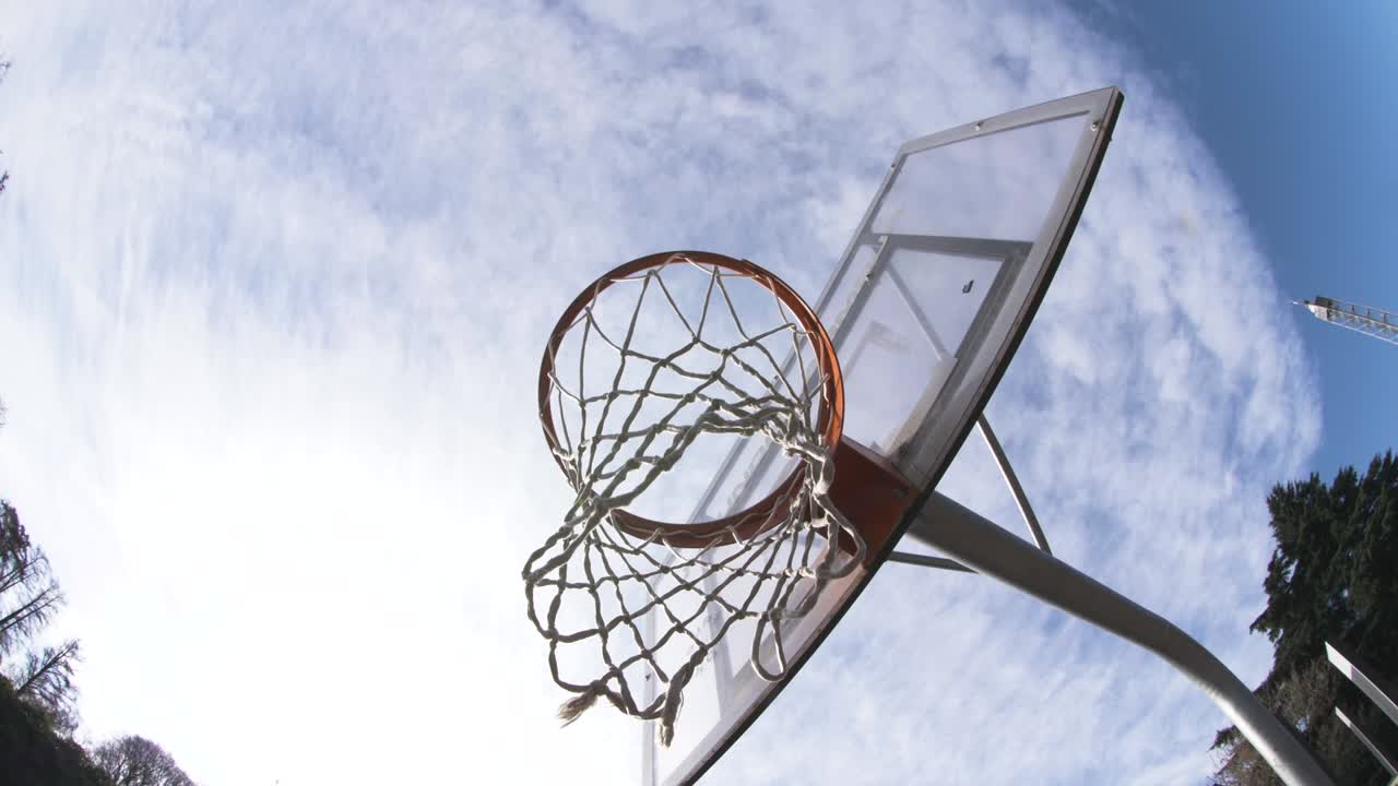 야외 놀이터에서 네트와 함께 농구 바구니. 카메라가 주위를 움직입니다.