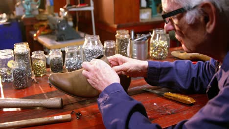 shoemaker examining a shoe