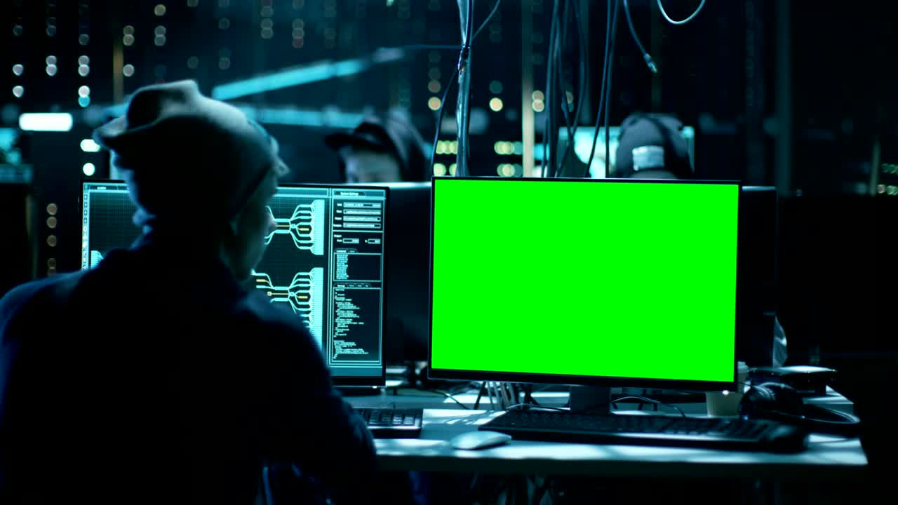 un team di hacker adolescenti ricercati a livello internazionale con un display a schermo verde infetta i server e le infrastrutture con malware. il loro nascondiglio è buio, illuminato al neon e ha più display.