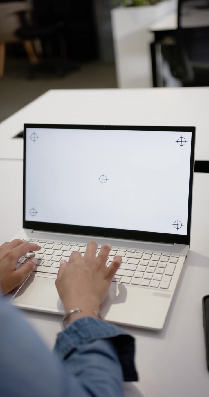 Vertikal video: Afroamerikansk kvinde hviler sig og taster derefter på bærbar computer ved bordet for arbejde med mål