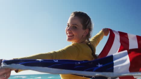 Mujer-Sosteniendo-La-Bandera-Americana-En-La-Playa