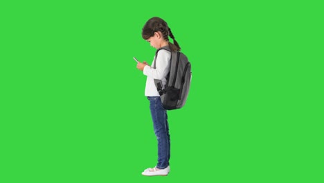 초록색 화면, 크로마 키에 그녀의 분홍색 드폰에 타이핑 배과 함께 집중 학교 소녀