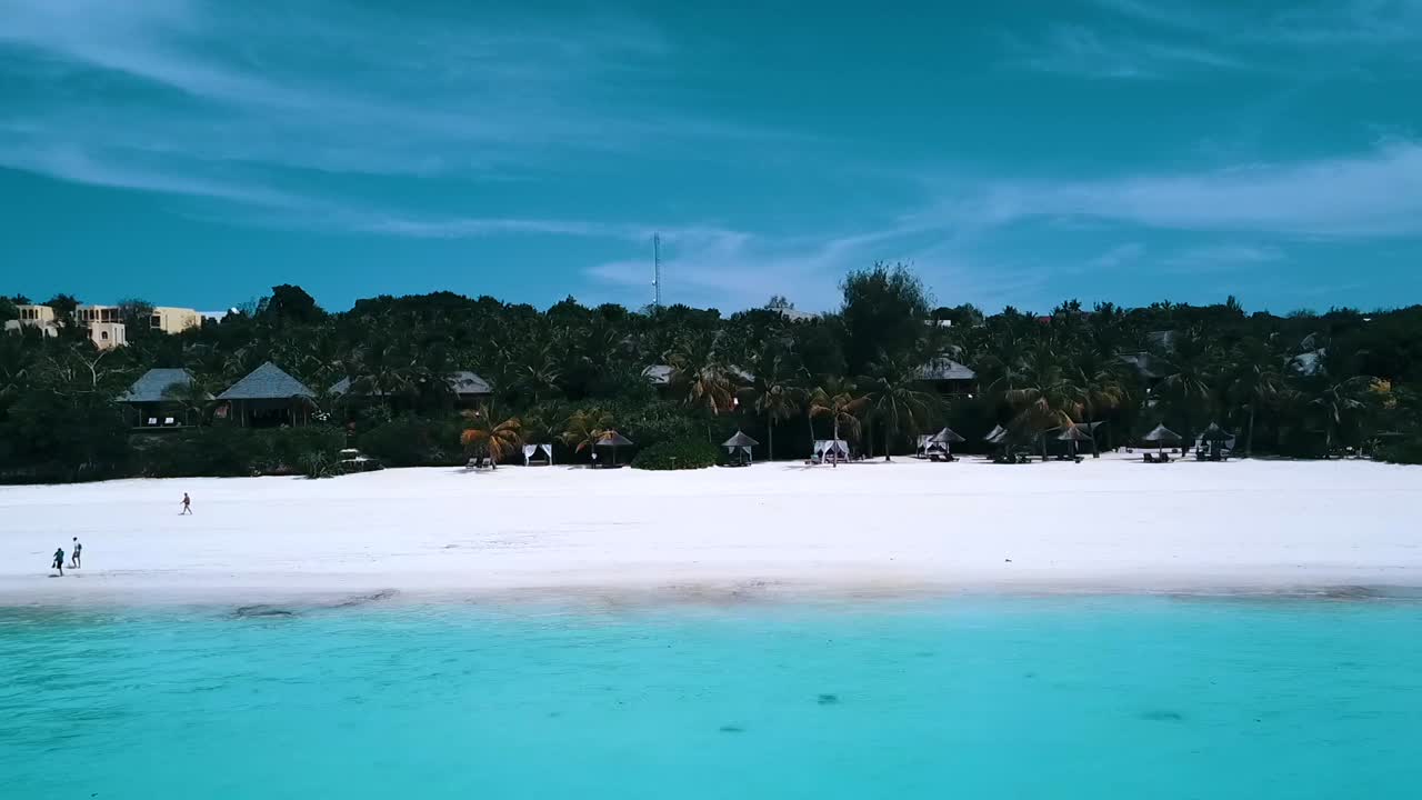 화려한 공중 비행 슬라이더는 왼쪽에서 오른쪽으로 드론 샷 백사장 청록색 물을 날립니다.