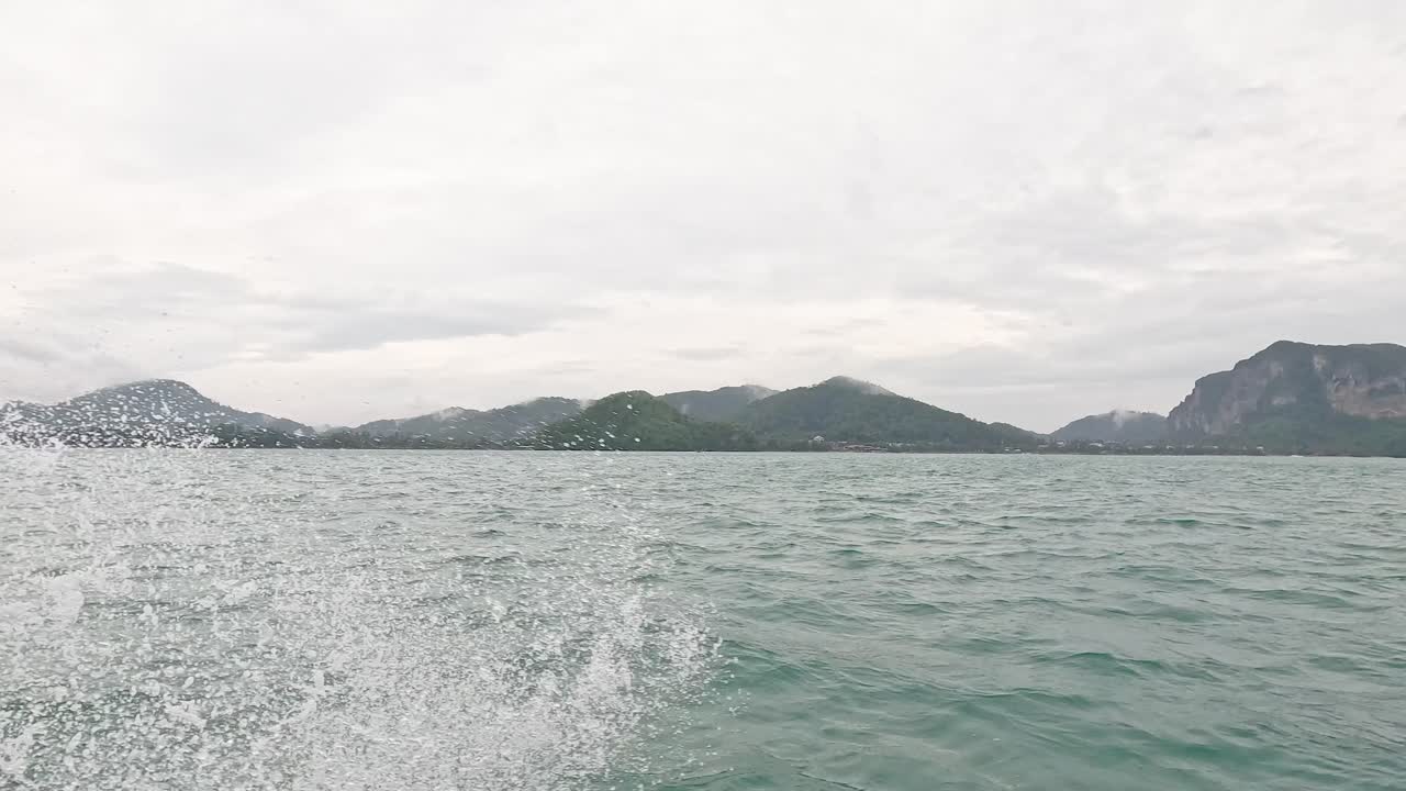 파도가 멀리 있는 산 근처의 배에 부히고