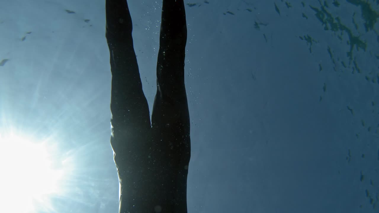un hombre buceando bajo el mar en un día soleado en paralia emplisi, grecia, europa- filmación submarina