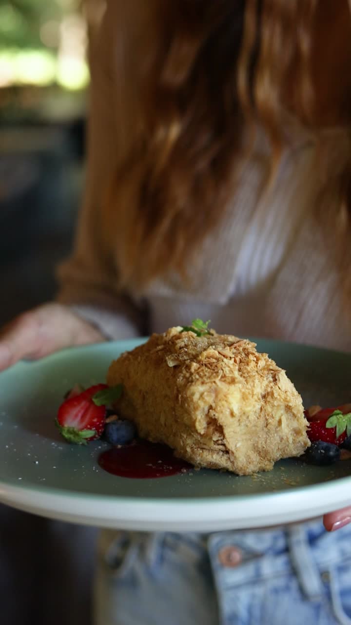 Woman holding a plate of Napoleon Cake