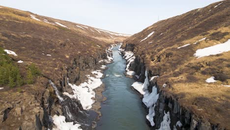 canyon with small waterfalls and a big river