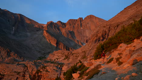 Cinematográfico-Primera-Luz-Amanecer-Naranja-Rojo-Excursionista-Anhela-Pico-14er-Amanecer-Parque-Nacional-De-Las-Montañas-Rocosas-Encima-De-La-Línea-De-árboles-Colorado-Denver-Roca-Parque-Estes-Verano-Dramático-Paisaje-Pan-Lentamente-A-La-Izquierda