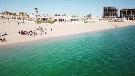 Drone-shot-of-a-group-of-college-students-on-a-Mexican-beach-during-Spring-Break