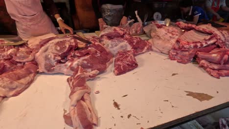 butcher cutting and arranging meat on counter