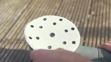 attaching a velcro sanding disc to an orbital sander