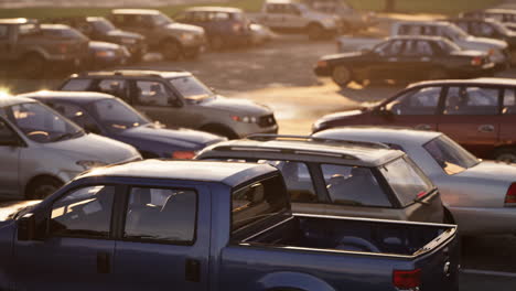 una camioneta azul estacionada en un estacionamiento al atardecer