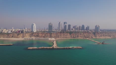 the coastline of netanya in israel, shot from the sea in front of stone pier