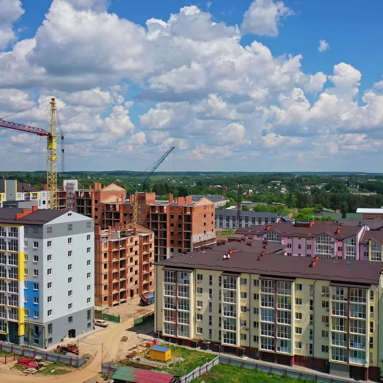 Construction of new residential district. Modern multi storey apartment buildings in construction site against blue sky. Tower crane build high rise buildings