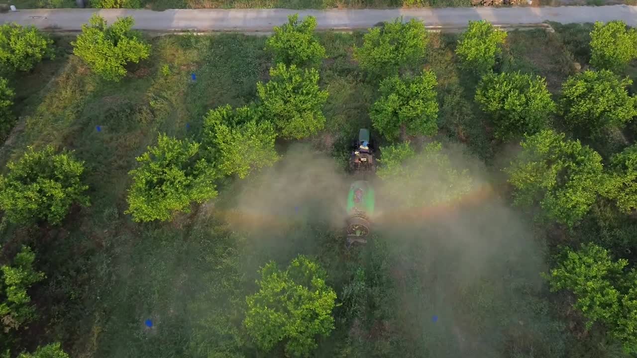 Tractor spraying pesticide drone aerial view, pesticides or insecticide spray on lettuce or iceberg field. Pesticides and insecticides on agricultural field in Spain