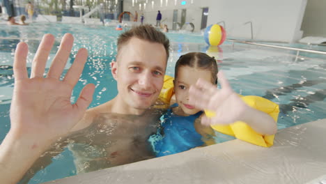 father and daughter enjoying time in indoor pool