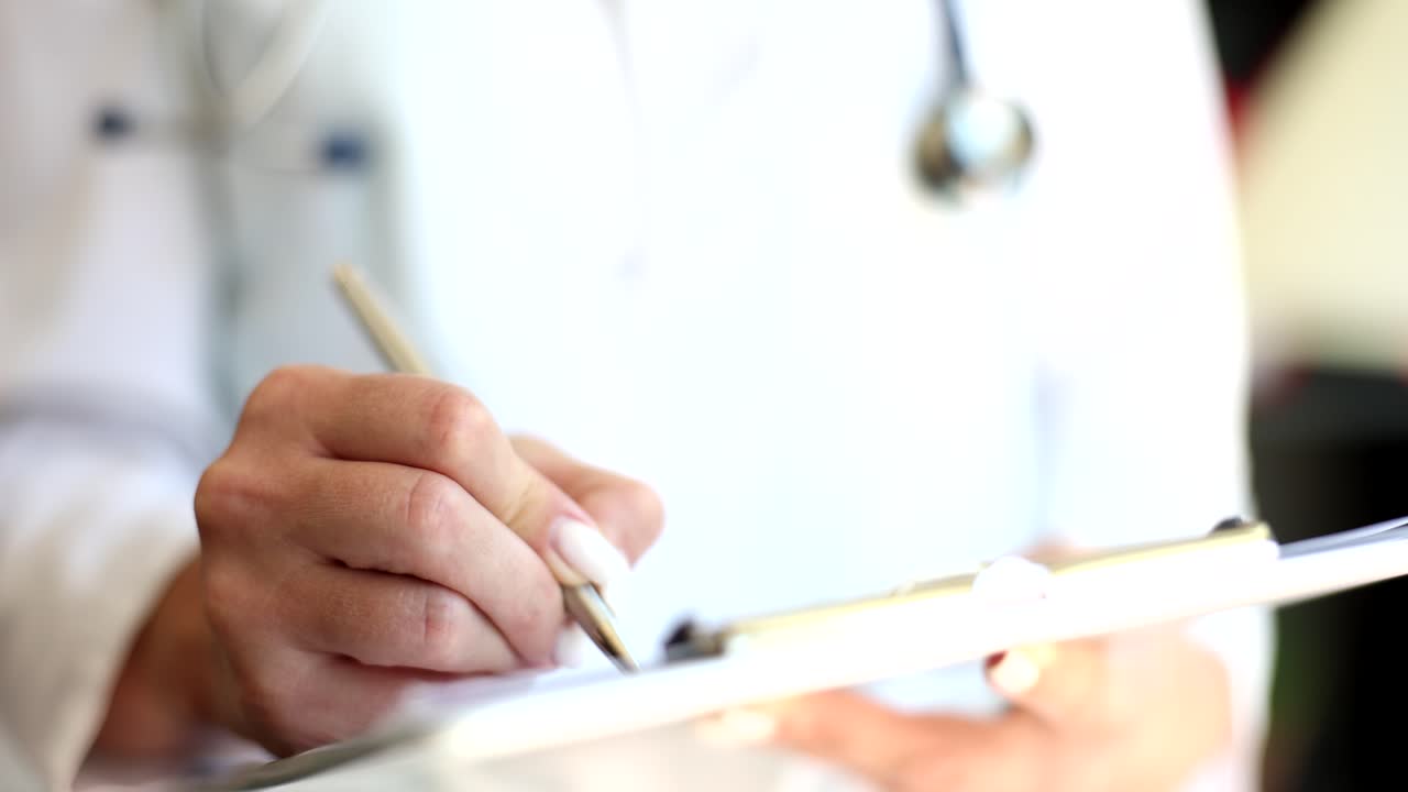 médico escribiendo en el clipboard