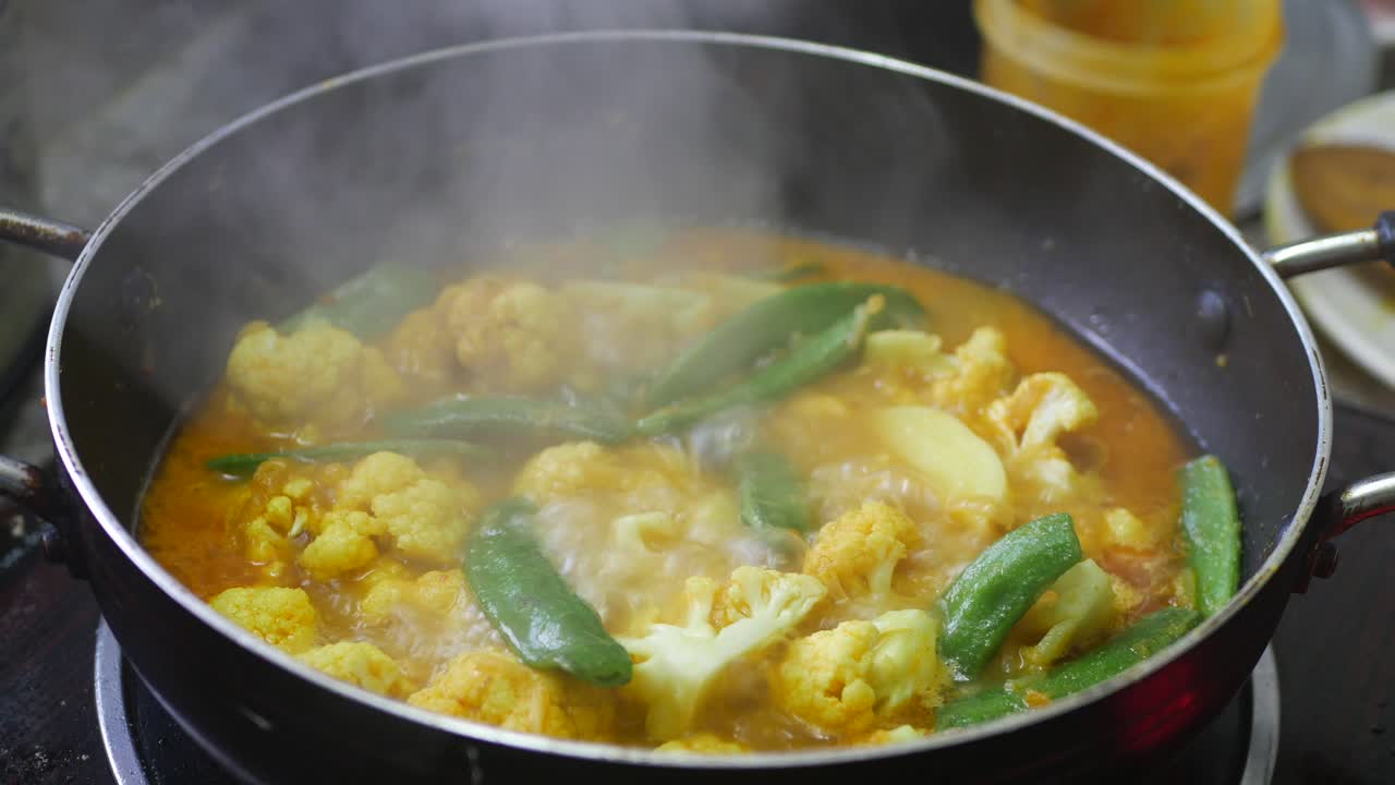 cocinar curry de verduras con coliflor y guisantes