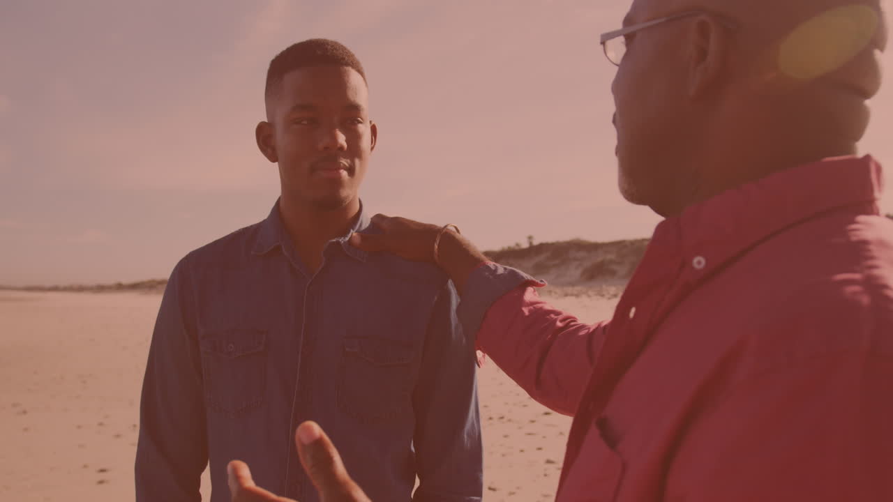 African american man talking to his son at the beach