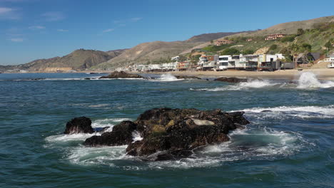 tormenta marina devastadora y espectacular - las olas del mar chocan contra las rocas de la costa creando una explosión de agua - los glaciares que se derriten aumentan el volumen del agua del mar