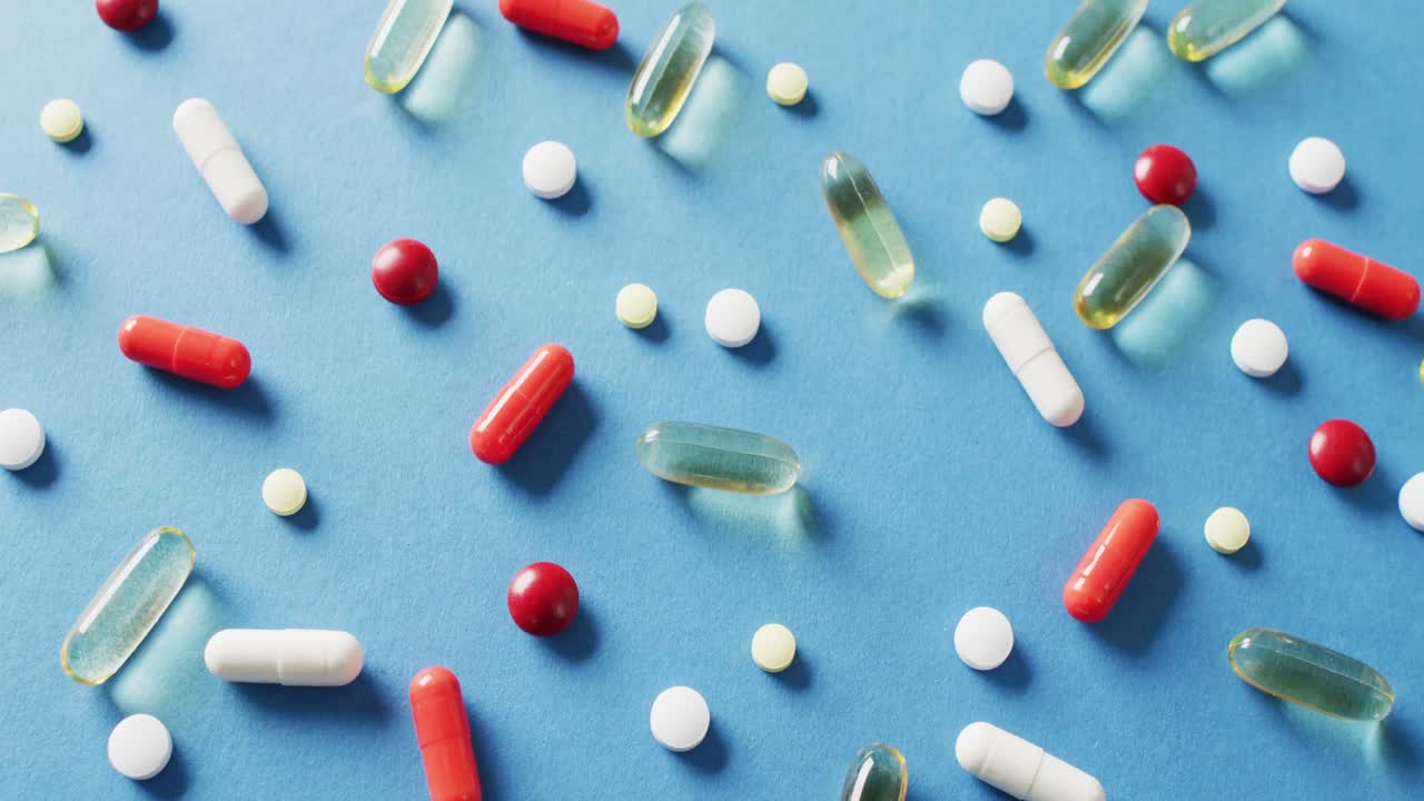 video de una variedad de píldoras y cápsulas sobre fondo azul