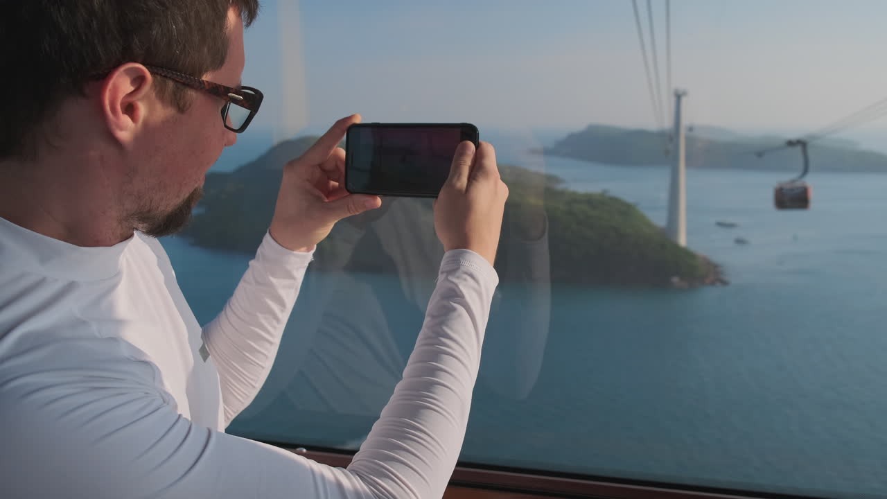 hombre tomando una foto de las islas y la vista del teleférico desde un teleférico