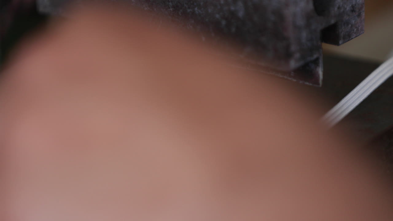 cortador automático de máquinas cortando la liga elástica para máscaras faciales en una fábrica de costura - pandemia de covid-19 - tiro derecho de la bandeja de cierre