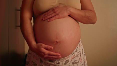 pregnant woman caressing her belly right on the skin