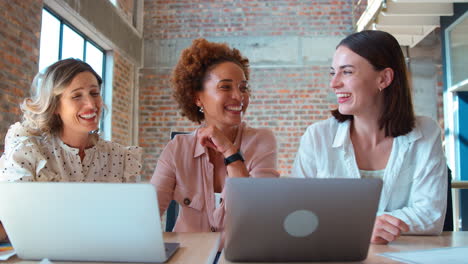 Equipo-De-Negocios-Multicultural-Femenino-Reunido-Alrededor-De-Una-Computadora-Portátil-En-La-Oficina