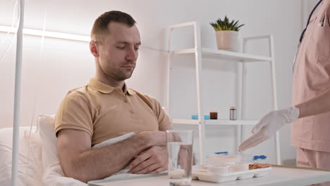 hombre comiendo comida traída por la enfermera