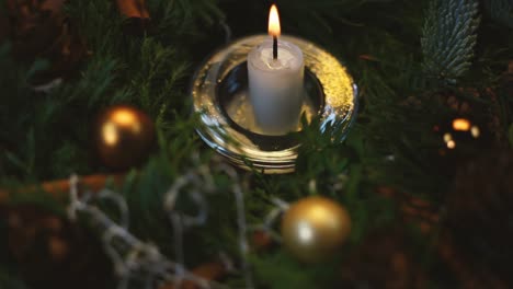 the woman lights a candle on an advent wreath, the background slightly blurred