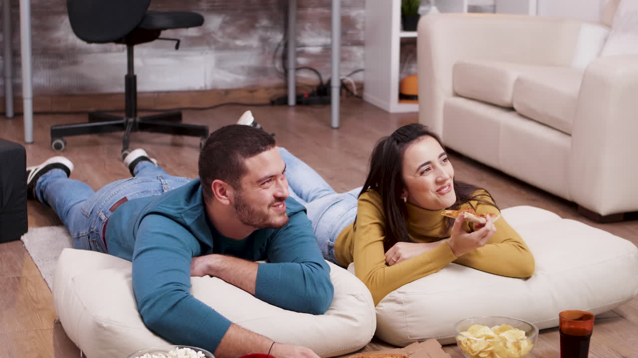 Couple Relaxing at Home Watching TV with Snacks