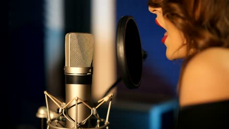 una joven grabando una canción en un estudio profesional.