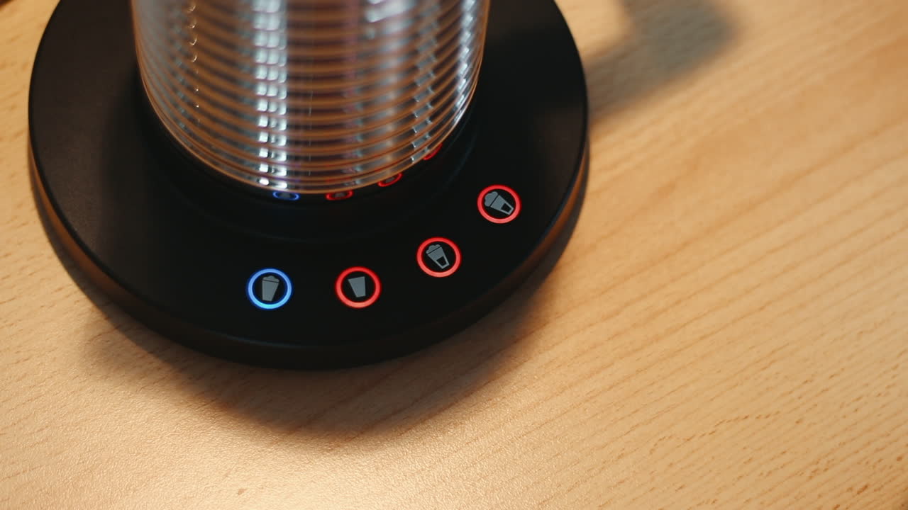 우유 거품기를 켜는 손가락