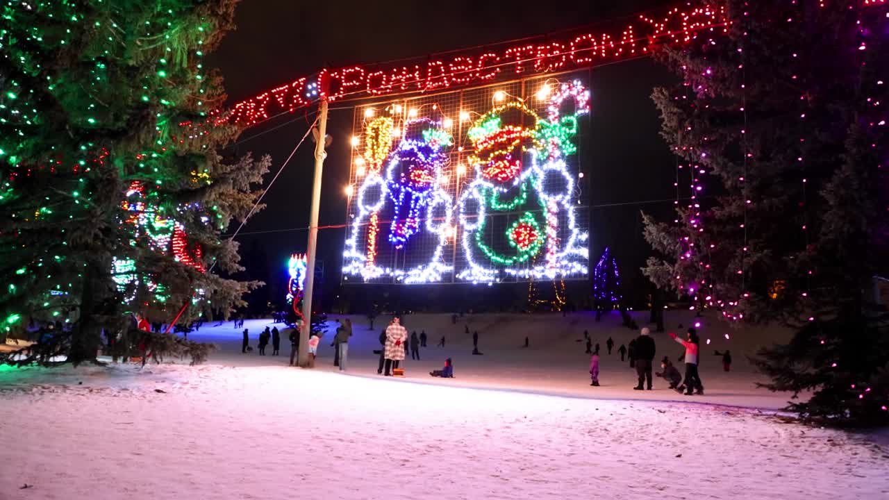 크리스마스 조명에 가까운 사람들이 라이온스 라이트 페스티벌에서 슬로건과 매를 타고있는 동안 캘거리에서 크리스마스 라이트 쇼케이스
