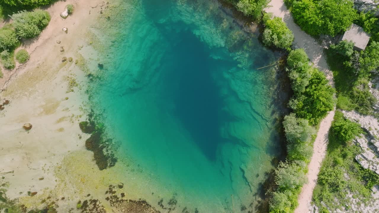 Rotazione e discesa aerea sulla sorgente d'acqua turchese del fiume Cetina, Croazia.