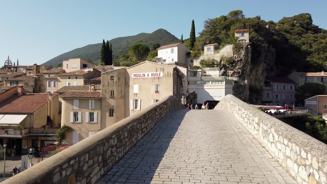 caminando por el puente histórico de la ciudad vieja junto al río en la provenza