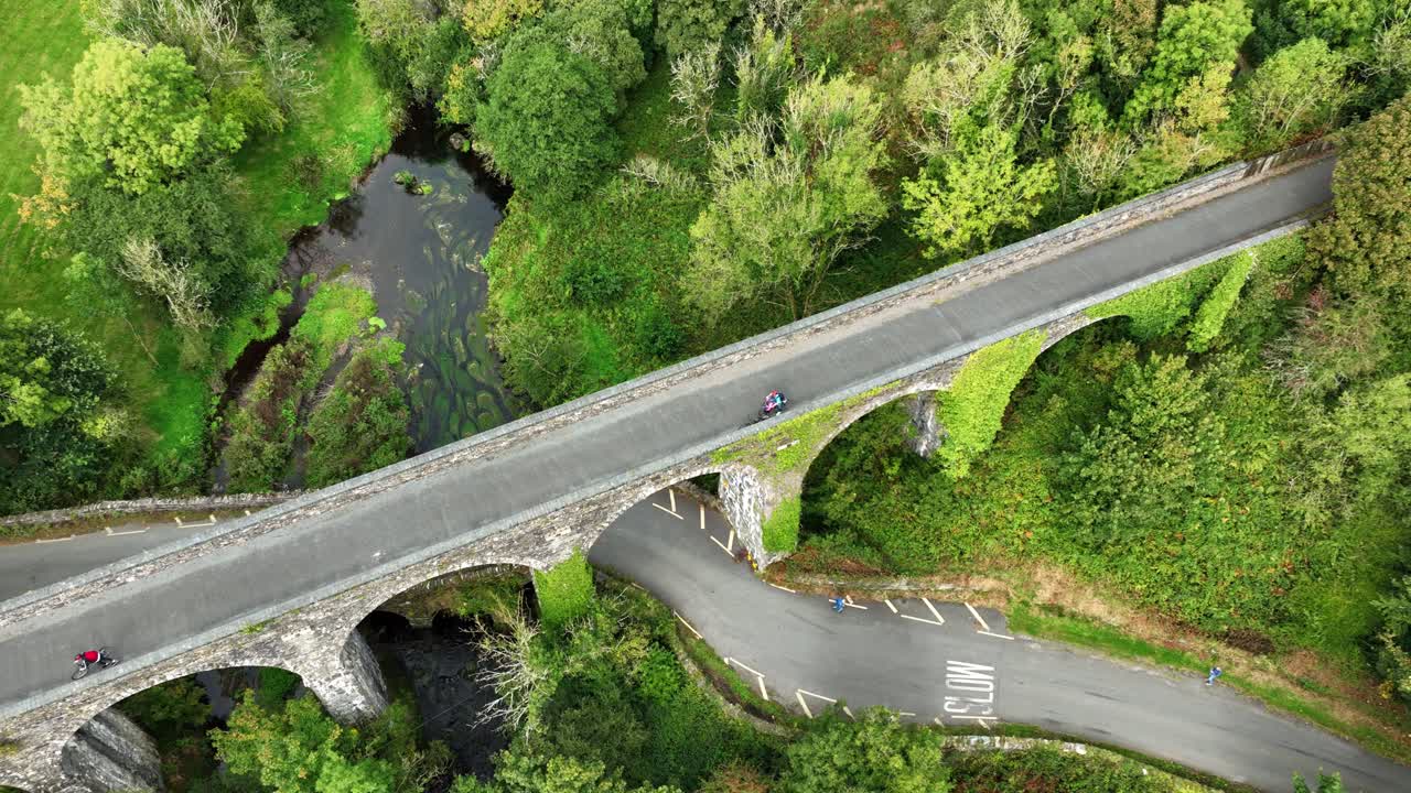 Ireland Epic Locations Durrow viaduct on The Waterford Greenway cyclists admiring the view of the river and roadway winding its way under the bridge, tourist attraction in Ireland