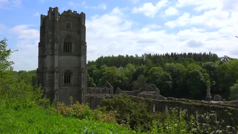 an abandoned cathedral abbey of rievaulx rises out of the forest in britain