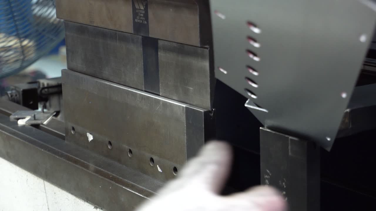 worker performing metal profiling for a soda machine