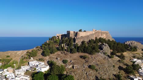 Akropolis-Von-Lindos-In-Rhodos,-Griechenland-Mit-Häusern-Und-Mittelmeer-Während-Des-Tages,-Gefilmt-Mit-Der-Drohne