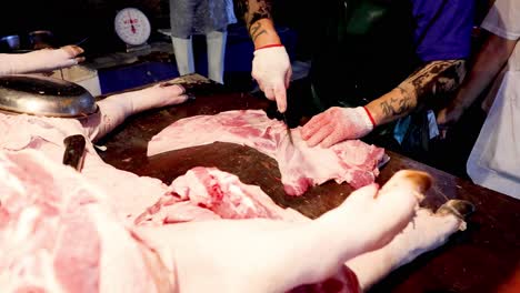 professional butcher efficiently cuts and trims pork.