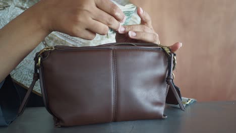 hands putting money into a purse